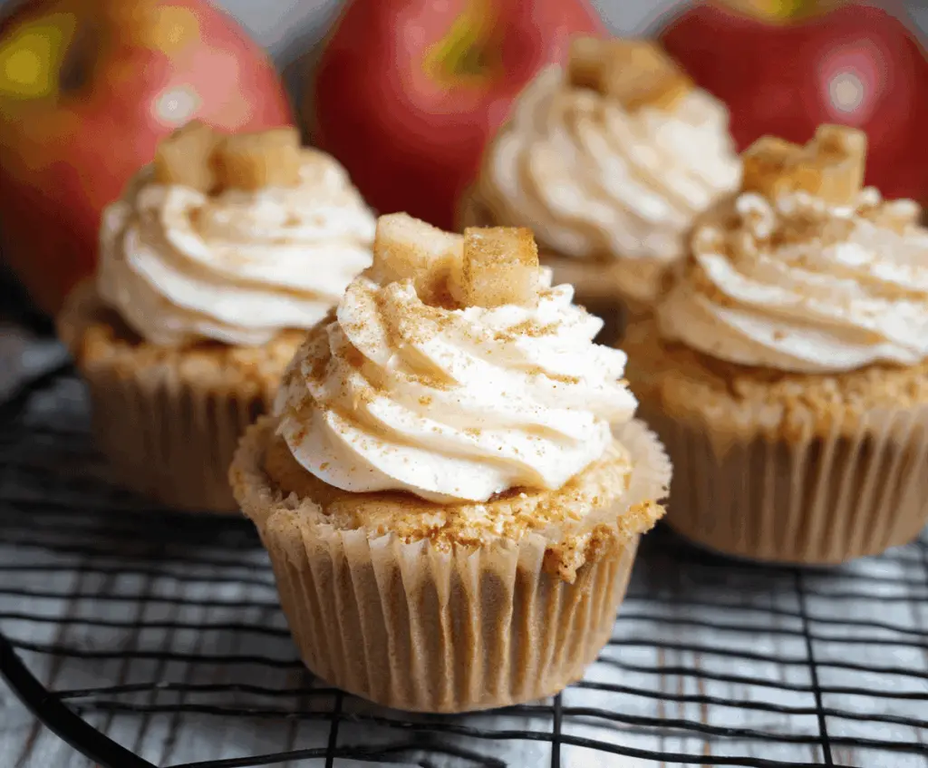 Delicious homemade apple pie cupcakes with cinnamon-spiced apple filling topped with golden crumb topping and a dusting of powdered sugar, perfect for dessert or fall gatherings.