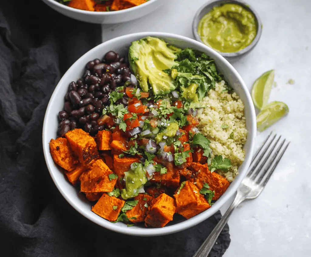 Delicious chipotle sweet potato burrito bowls featuring roasted sweet potatoes, black beans, fresh vegetables, and flavorful toppings in a vibrant, appetizing presentation.