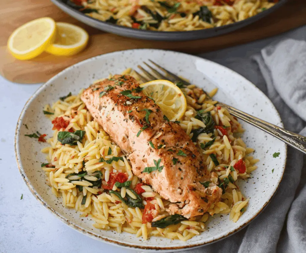 Delicious one skillet salmon with lemon orzo served on a plate, garnished with fresh herbs and lemon wedges for a flavorful seafood dinner