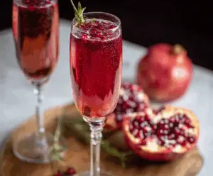 Refreshing Pomegranate Prosecco Cocktail in a elegant glass garnished with pomegranate seeds and mint leaves