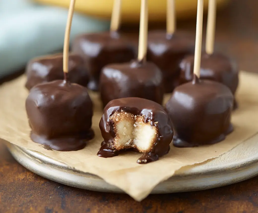 Delicious chocolate-covered banana bites arranged on a white plate, perfect for a sweet snack or dessert