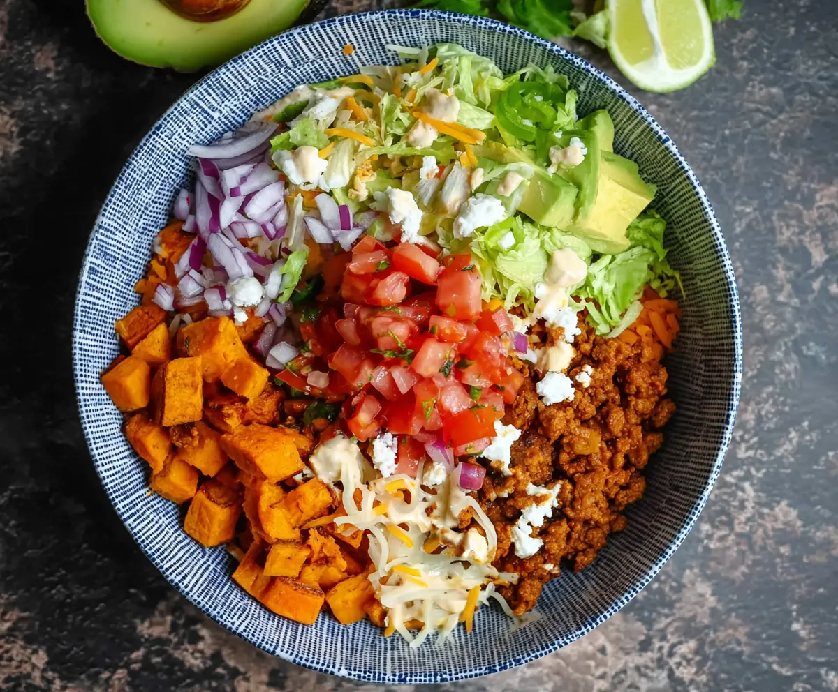 Colorful sweet potato taco bowl with fresh vegetables and flavorful toppings.