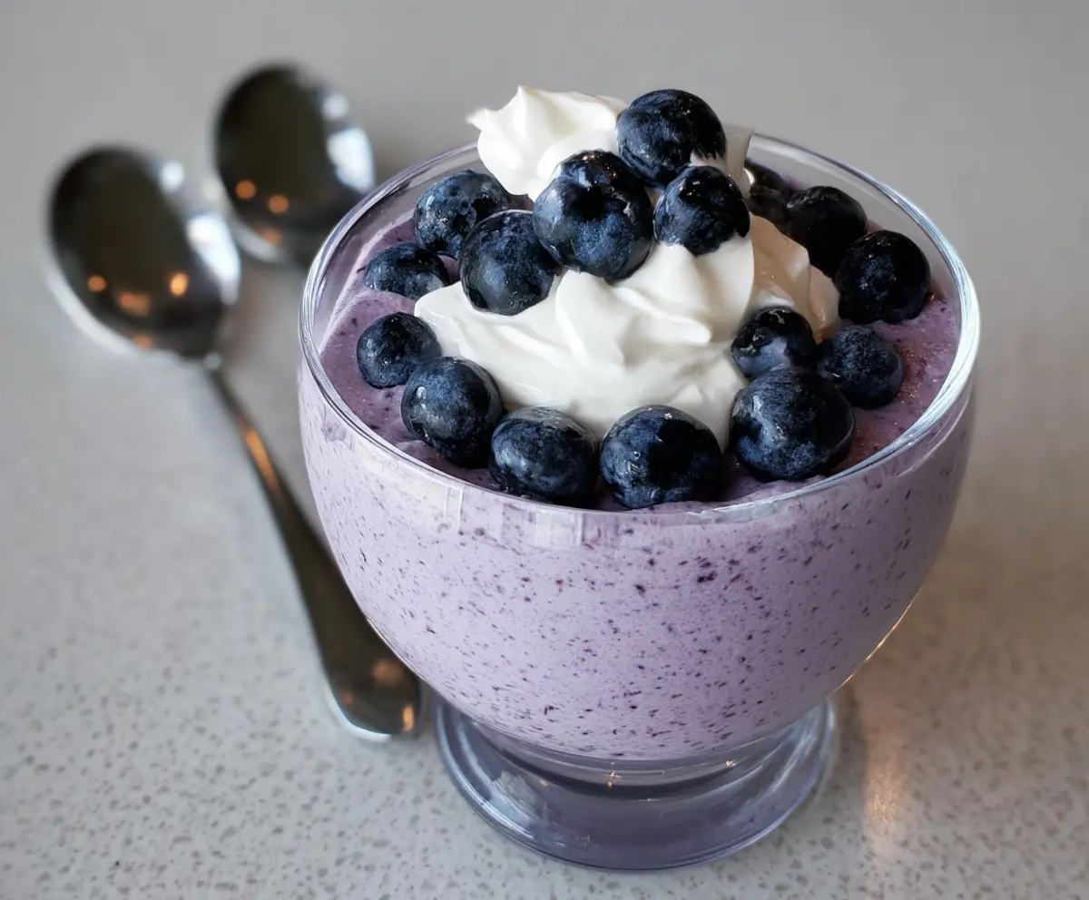Creamy blueberry cottage cheese mousse garnished with fresh blueberries and mint.