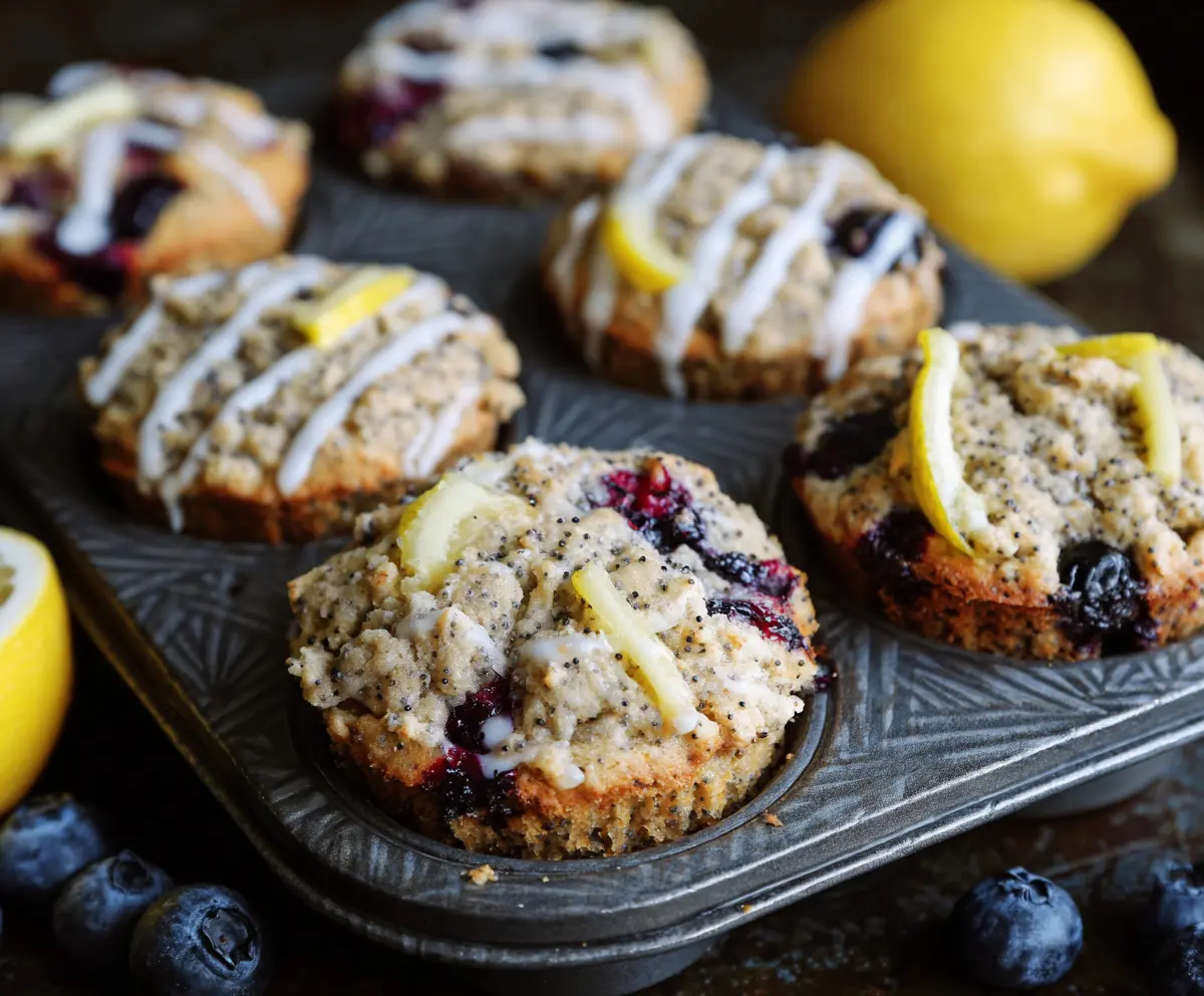 Homemade blueberry lemon poppy seed sourdough muffins on a rustic baking tray.