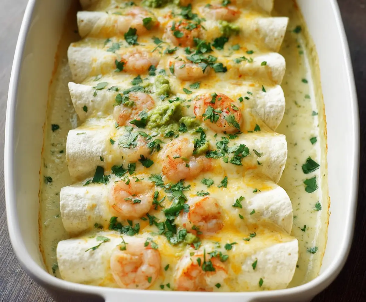 Delicious shrimp enchiladas topped with creamy poblano sauce served on a rustic plate.
