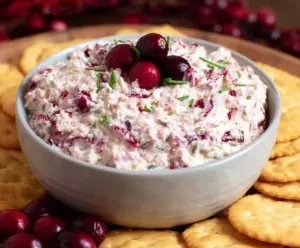 Creamy cranberry jalapeno dip with fresh herbs in a bowl, perfect for appetizers and parties.