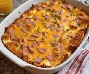 Delicious Easter Cheesy Ham and Egg Casserole topped with melted cheese and fresh herbs
