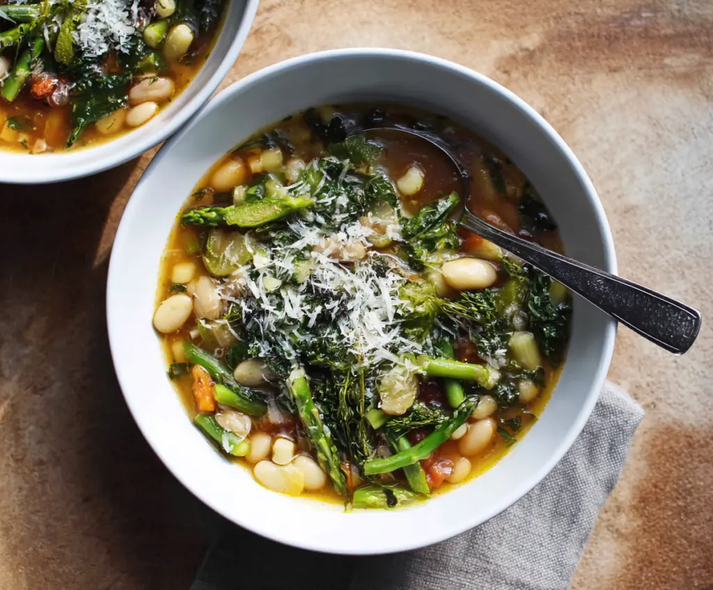 Hearty Spring Minestrone Soup with fresh vegetables and herbs in a bowl