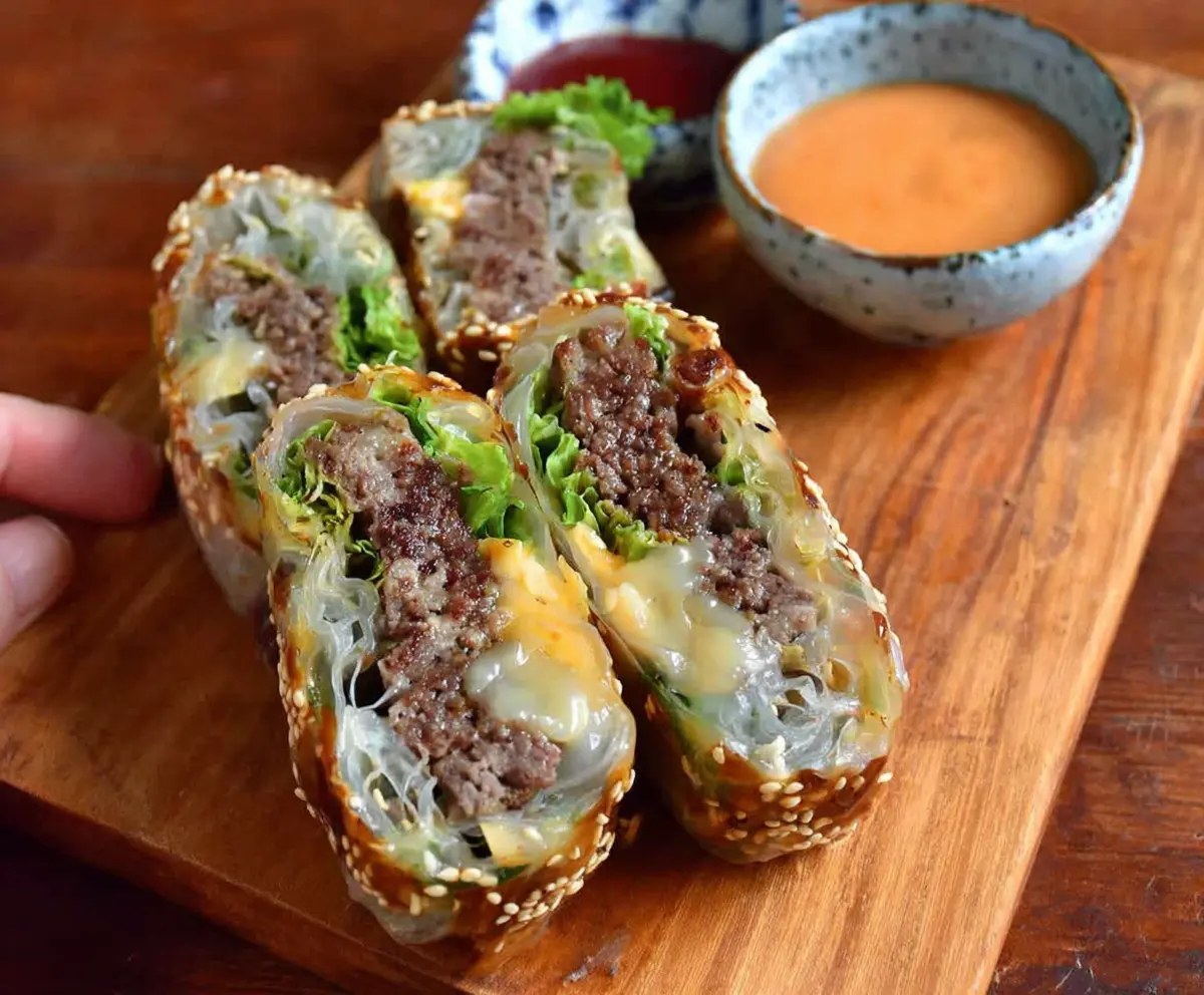 Delicious Big Mac Rice Paper Rolls with lettuce, cheese, and beef filling on a white plate.