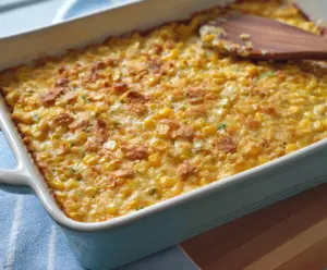Creamy scalloped corn with a golden-brown crust and melted cheese served in a rustic bowl.